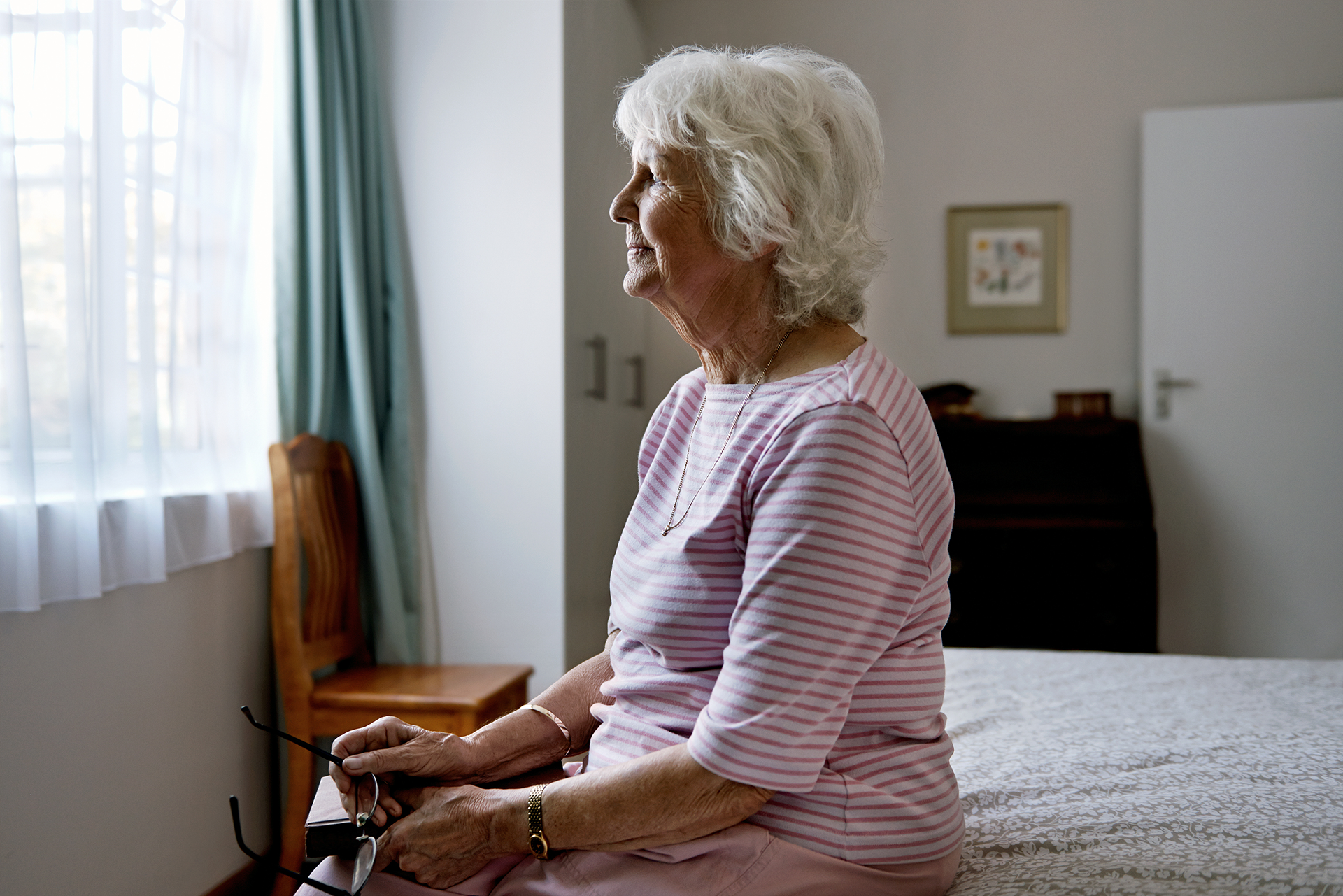Hospice patient sitting on bed at home