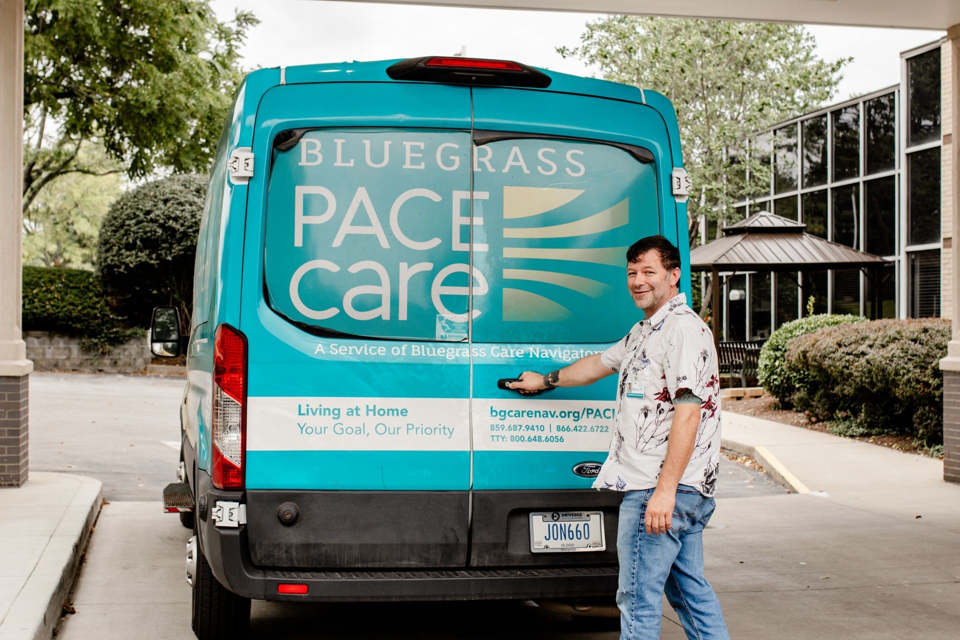 Man holds the handle on the back door of a PACE transport van.
