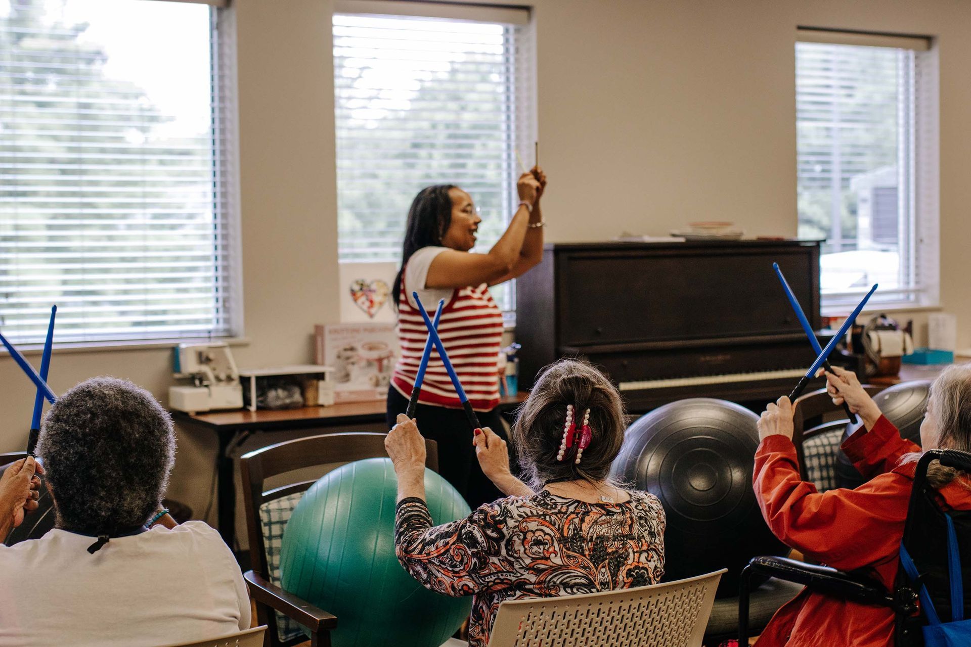 PACE Activities Director leads an activity with drumsticks for PACE participants.
