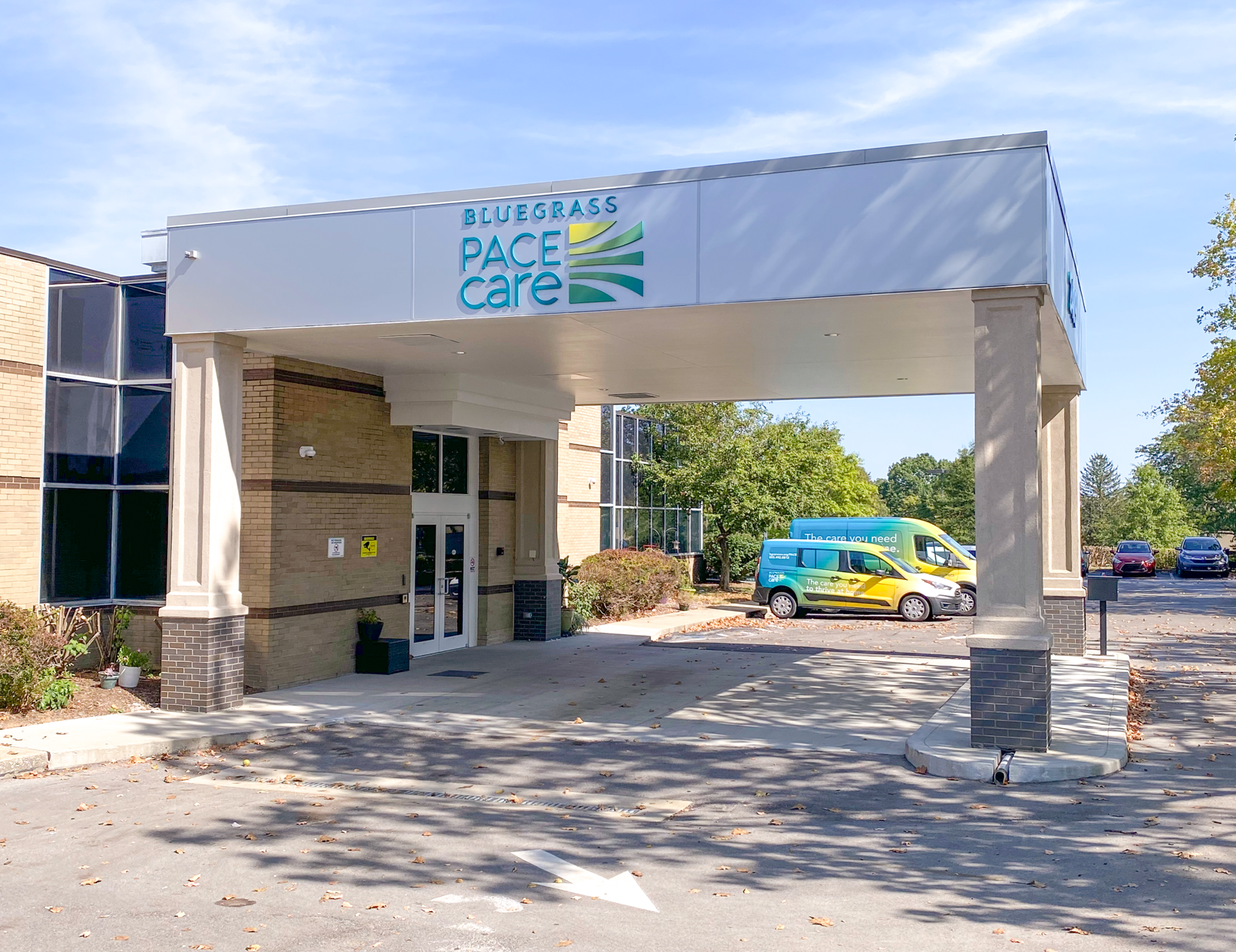 Front entrance of the Bluegrass PACE Center with the parking lot visible with PACE transport vehicles visible.
