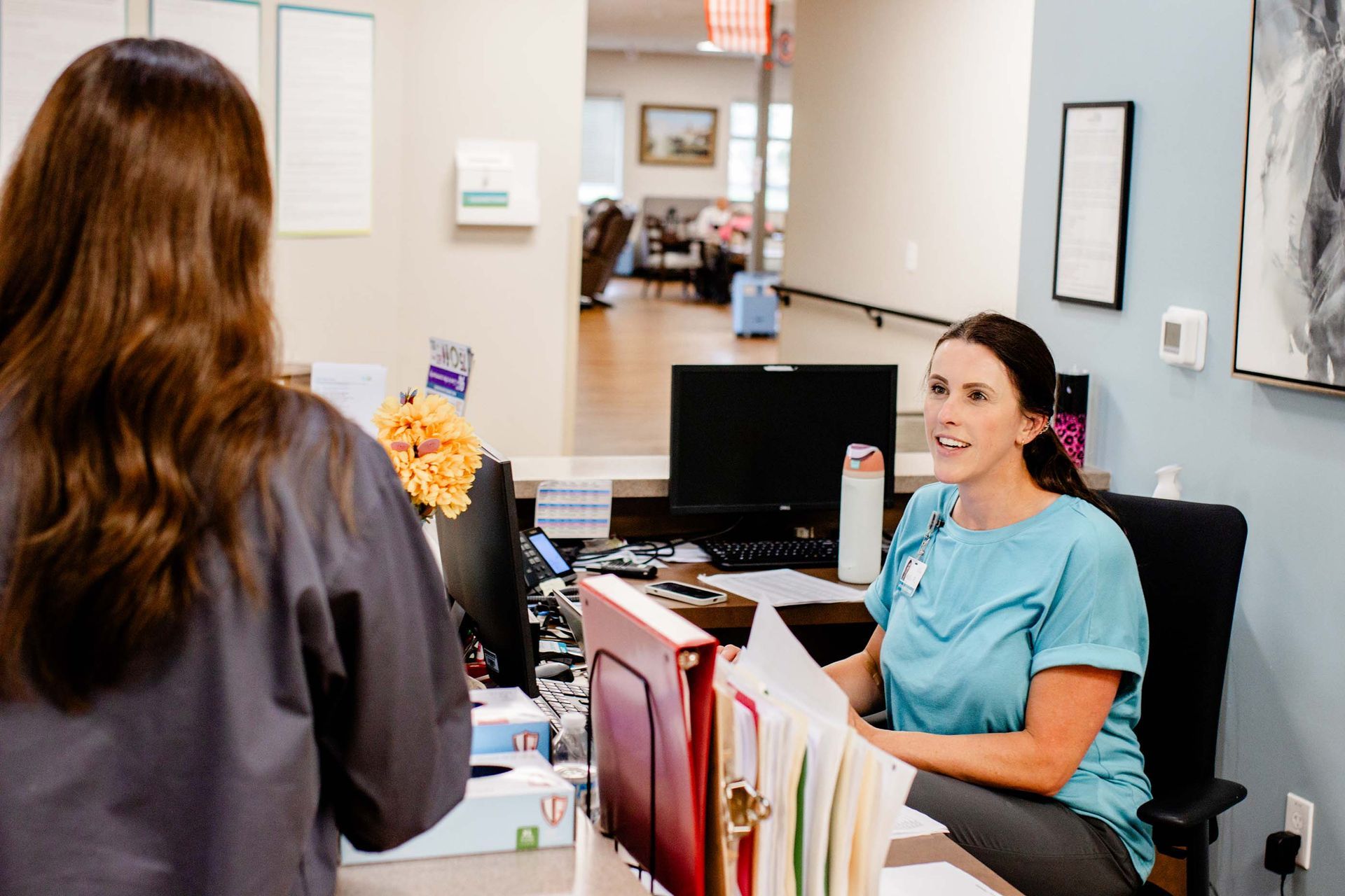 Receptionist works at the front desk of a PACE Center.
