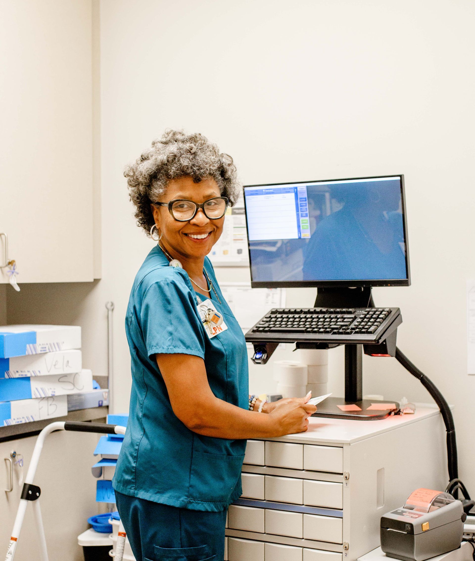 PACE team member standing at a computer in a patient care area of the Bluegrass PACE Center.
