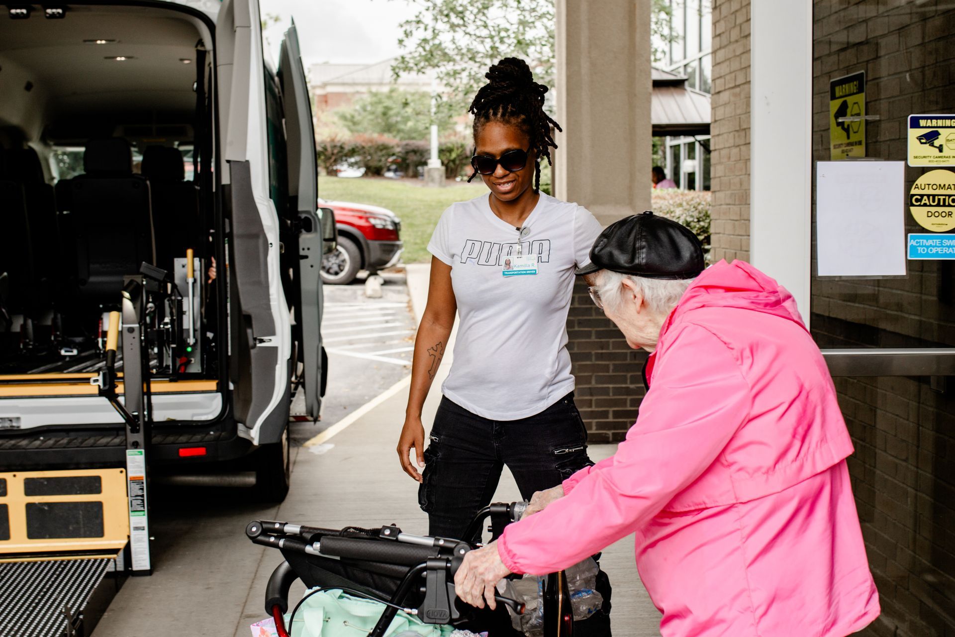 PACE transport driver helps a participant enter a PACE transport van.
