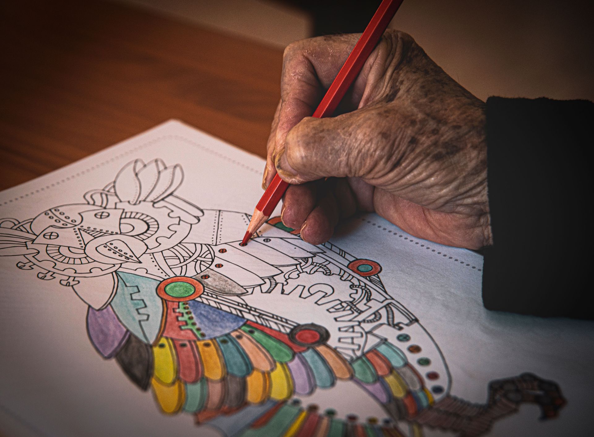 An adult coloring in a coloring book.