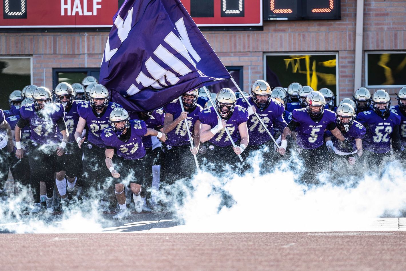 HF state championship run out with flags and smoke at CSU Pueblo.