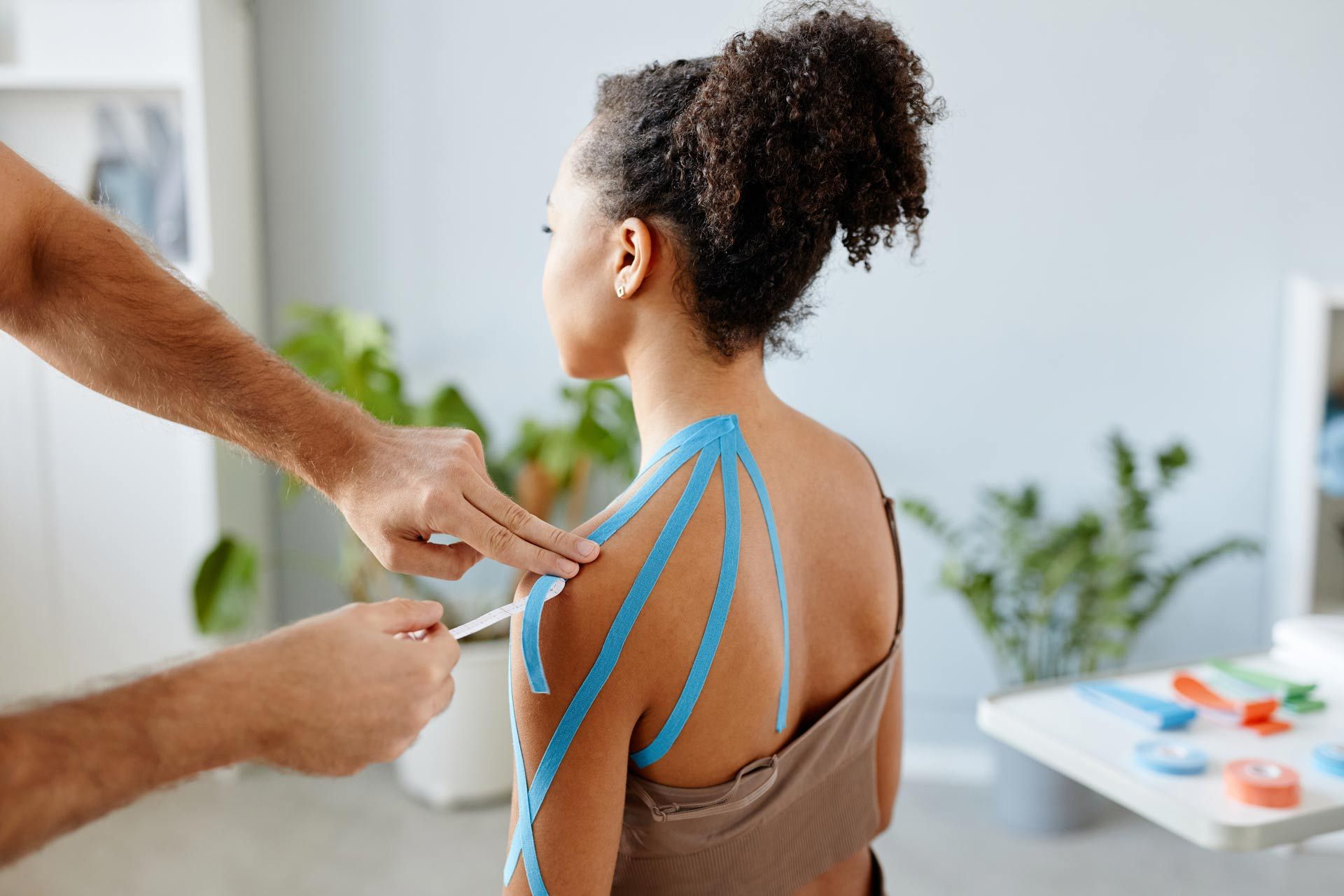 Therapist-Putting-Physio-Tape-on-Young-Woman