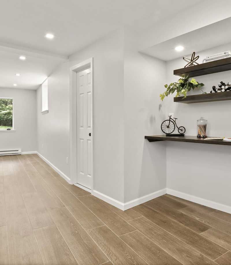 A hallway with hardwood floors and a shelf with a bicycle on it — Westchester, NY — Precision Tile, Marble & Masonry A hallway with hardwood floors and a shelf with a bicycle on it — Westchester, NY — Precision Tile, Marble & Masonry