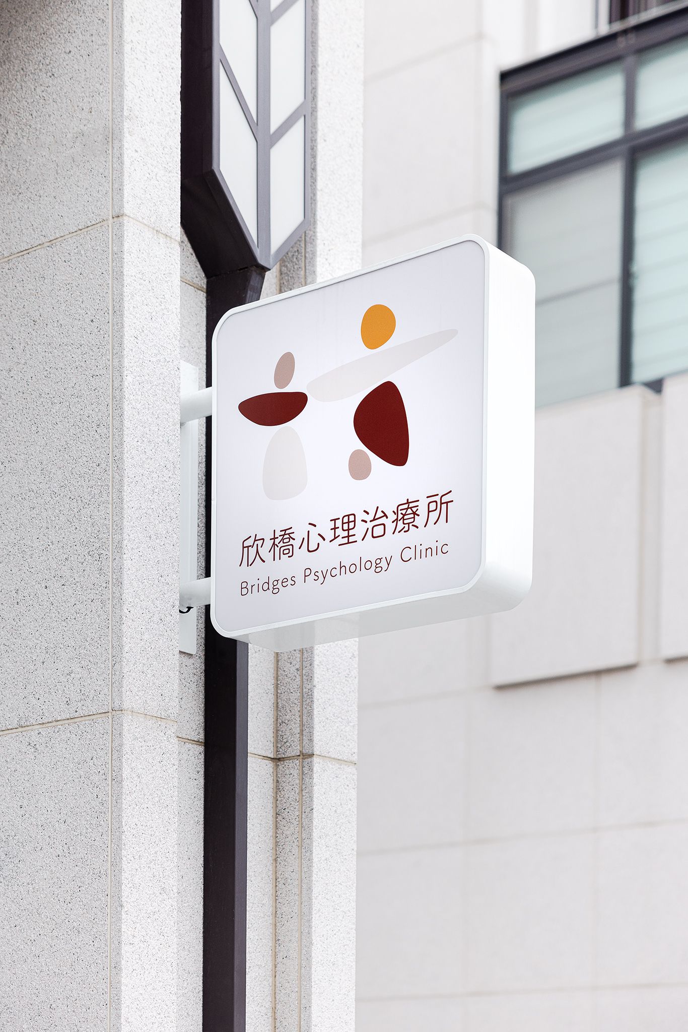 安裝在建築物上的企業招牌,白色,帶有兩個人物的標誌,顏色分別為紅色、棕色和米色。