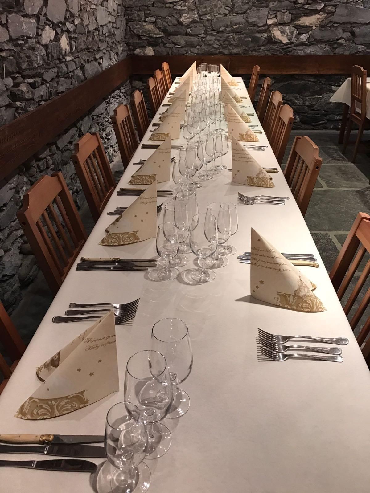 Une longue table et des chaises dans une pièce avec un mur en pierre.