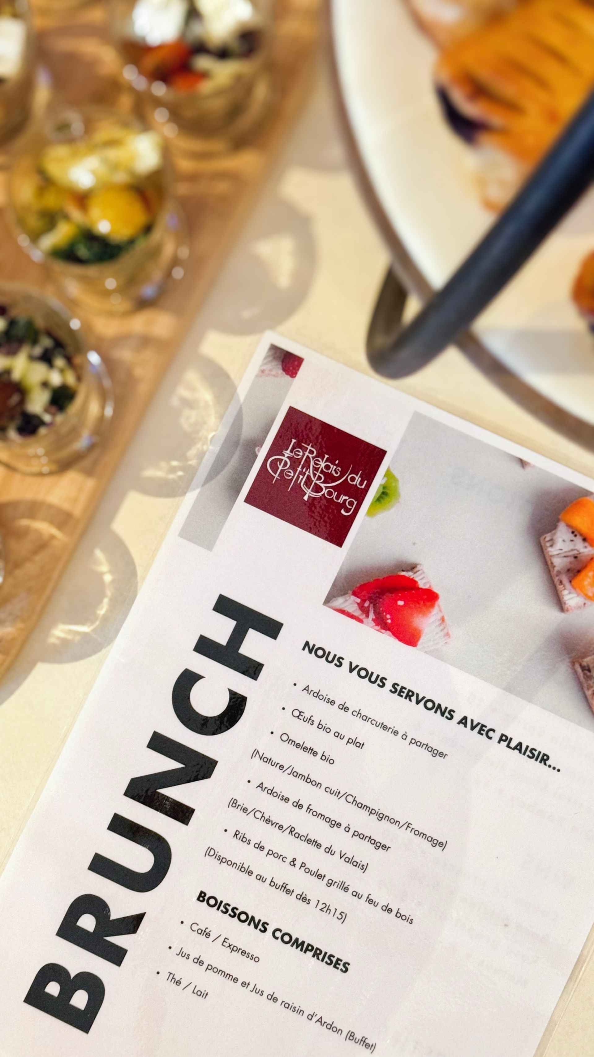 Un menu brunch est posé sur une table à côté d'une assiette de nourriture.