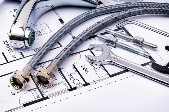 Blue and silver plumbing hoses and fittings on a technical blueprint drawing