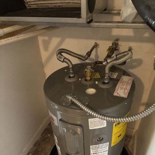 Water heater with connected pipes and valves in a utility closet