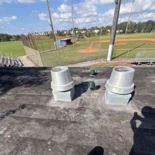 Rooftop vents overlooking a baseball field on a sunny day