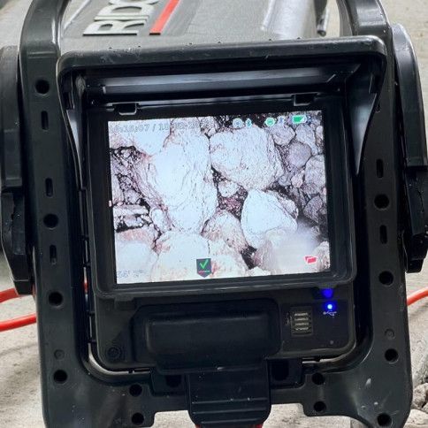 Camera screen showing a close-up of pale rocks or ice inside a black device frame
