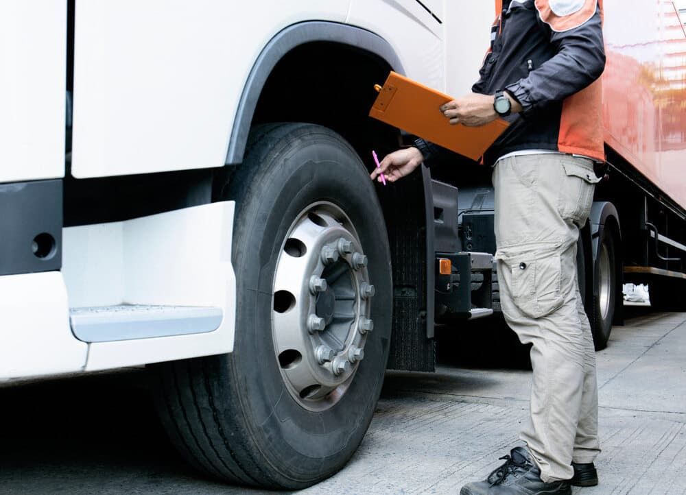 A Man Is Standing Next to A Truck Holding a Clipboard — Coast Mechanical Services In Berkeley Vale, NSW