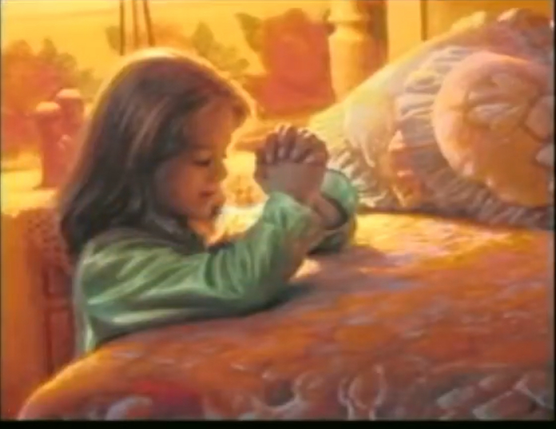 A little girl is praying on a bed with her hands folded