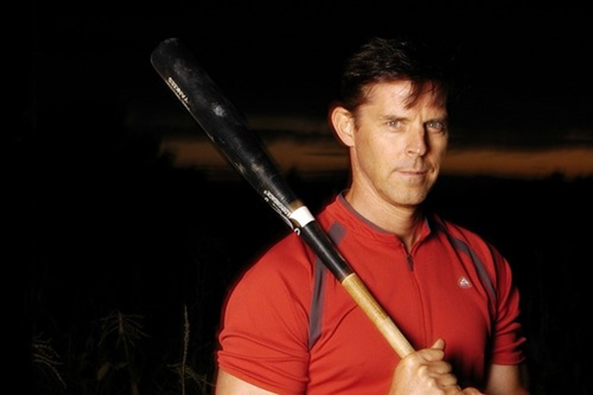 Tom Wright in a red shirt holding a baseball bat