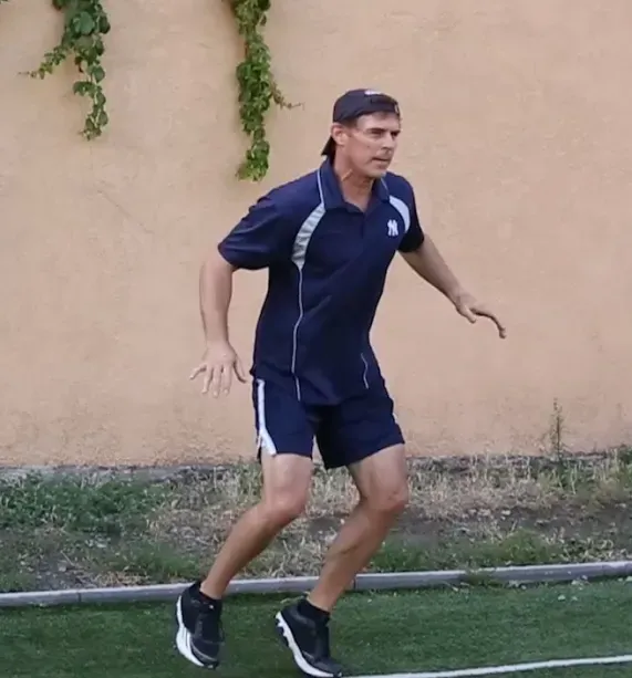 Tom Wright in a blue shirt and shorts is running on a field