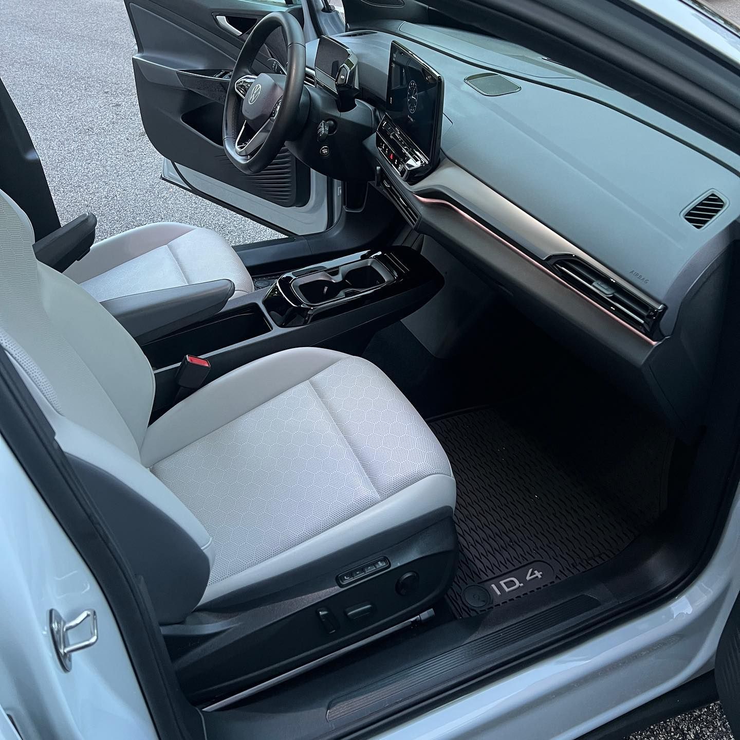 Open car door showing a gray and black modern interior with front seats and dashboard