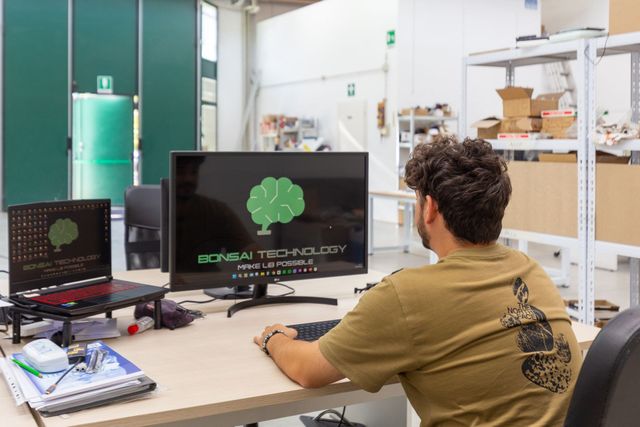 File di pacchi batteria argentati su una linea di assemblaggio automatizzata in fabbrica con macchinari aerei