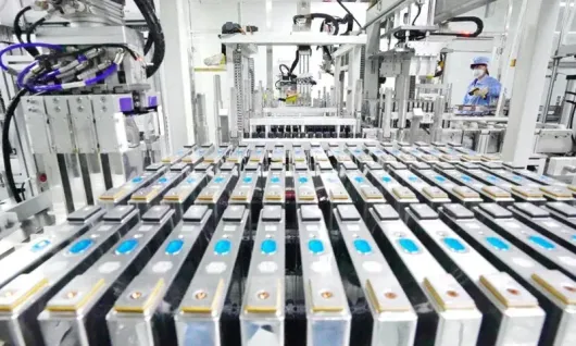 File di pacchi batteria argentati su una linea di assemblaggio automatizzata in fabbrica con macchinari aerei