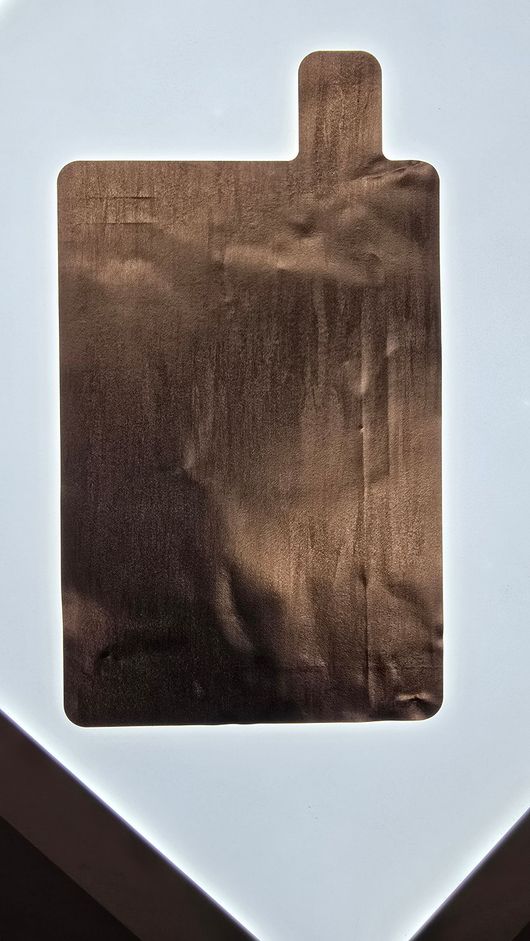 File di celle di batteria su una linea di produzione automatizzata in fabbrica, con apparecchiature robotiche in alto.