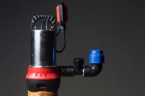 A Red And Black Submersible Water Pump Is Sitting On Top Of A Wooden Pole - Oklahoma City, OK - Total Pump & Supply A Red And Black Submersible Water Pump Is Sitting On Top Of A Wooden Pole - Oklahoma City, OK - Total Pump & Supply