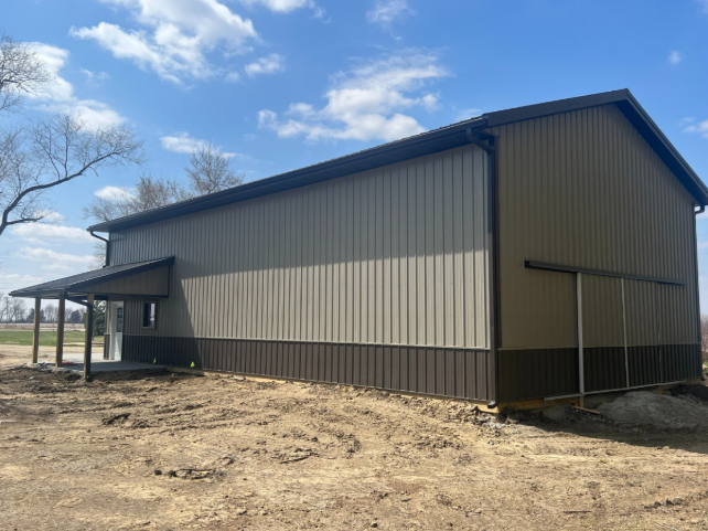 A large metal building with a porch on the side