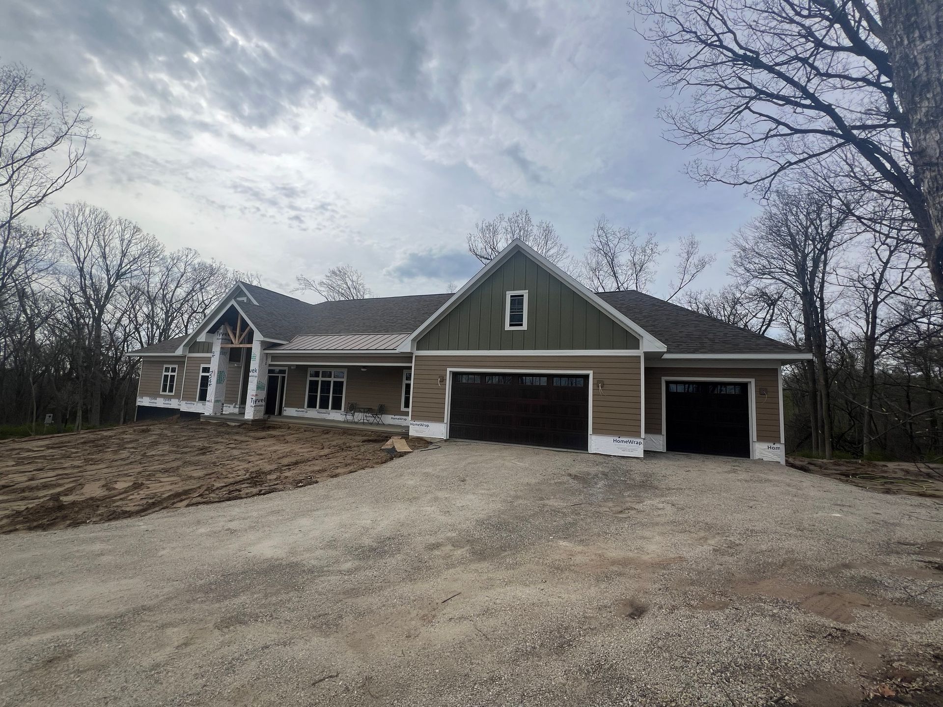A large house with two garages and a driveway in front of it.