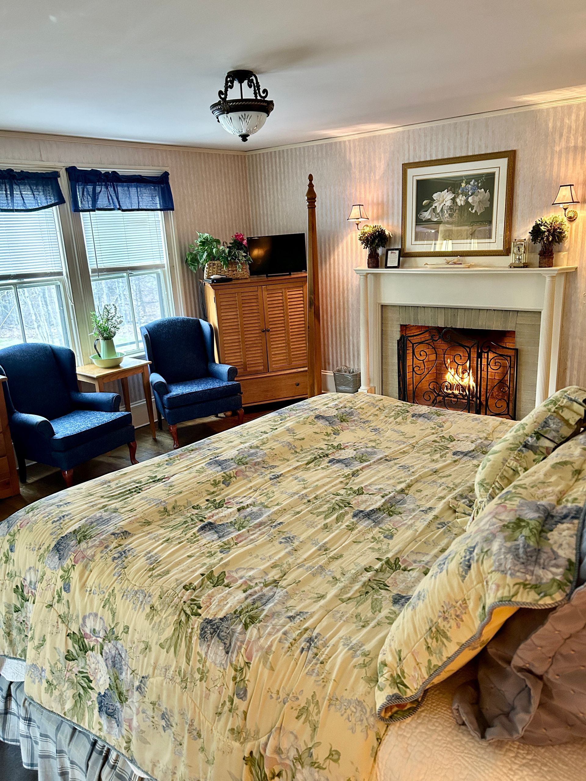 A bedroom with a king size bed and a fireplace