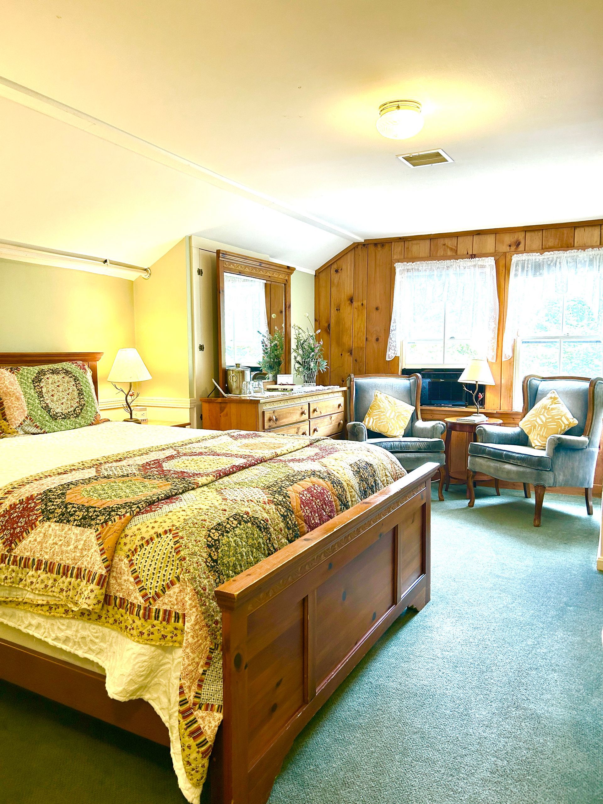 A bedroom with a king size bed and chairs
