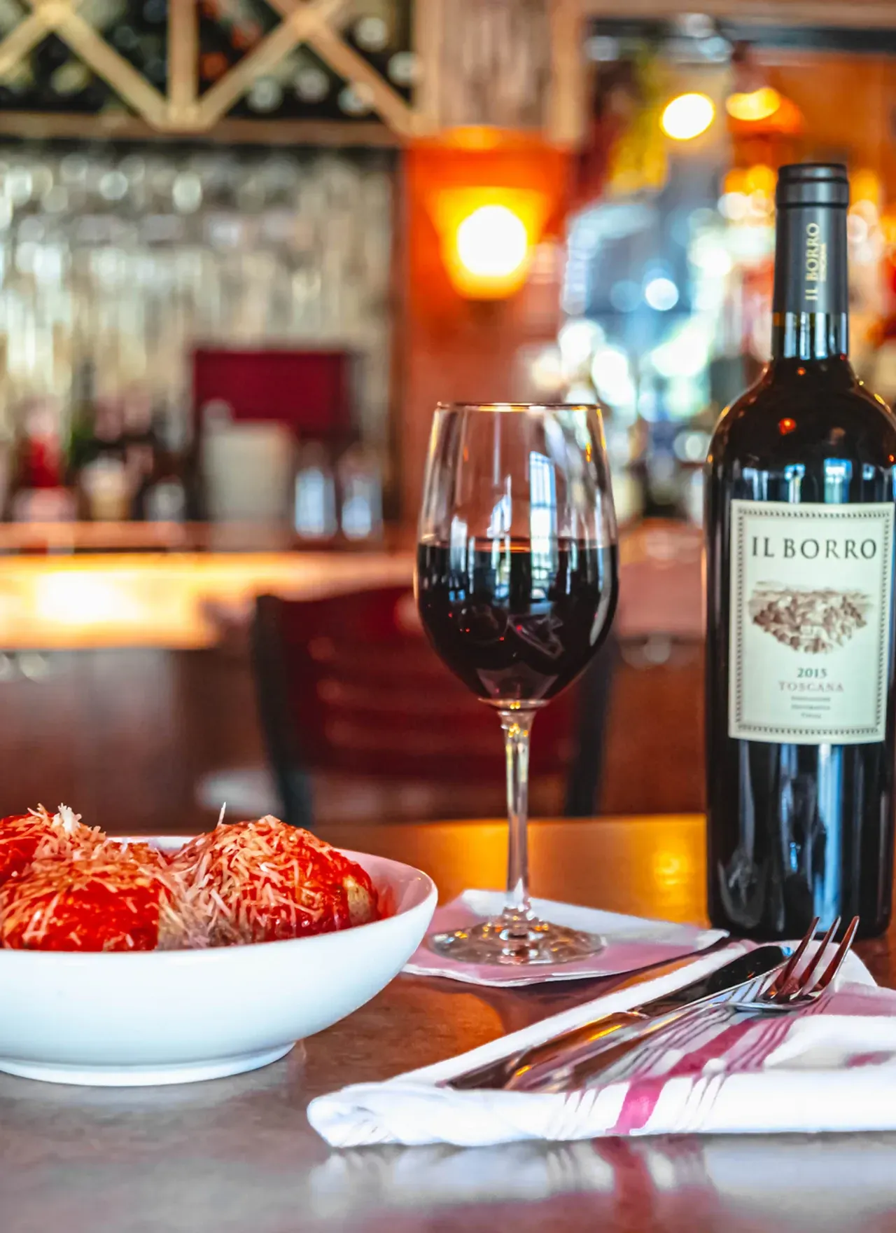 A bottle of el borro wine next to a glass of wine