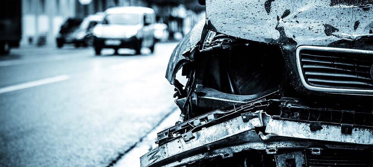 A damaged car is parked on the side of the road.