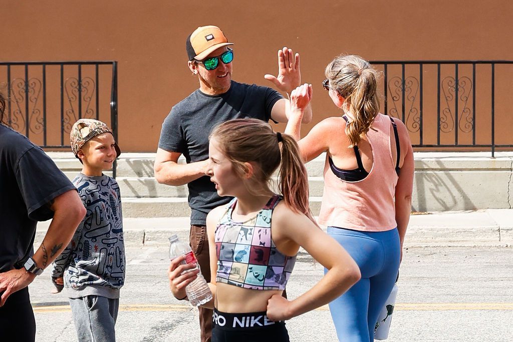 People standing outdoors in bright sun, chatting and stretching near Fortitude FItness in Buena Vista, CO