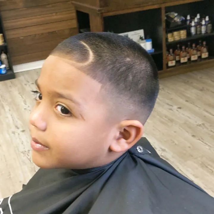 A young boy is getting his hair cut at a barber shop