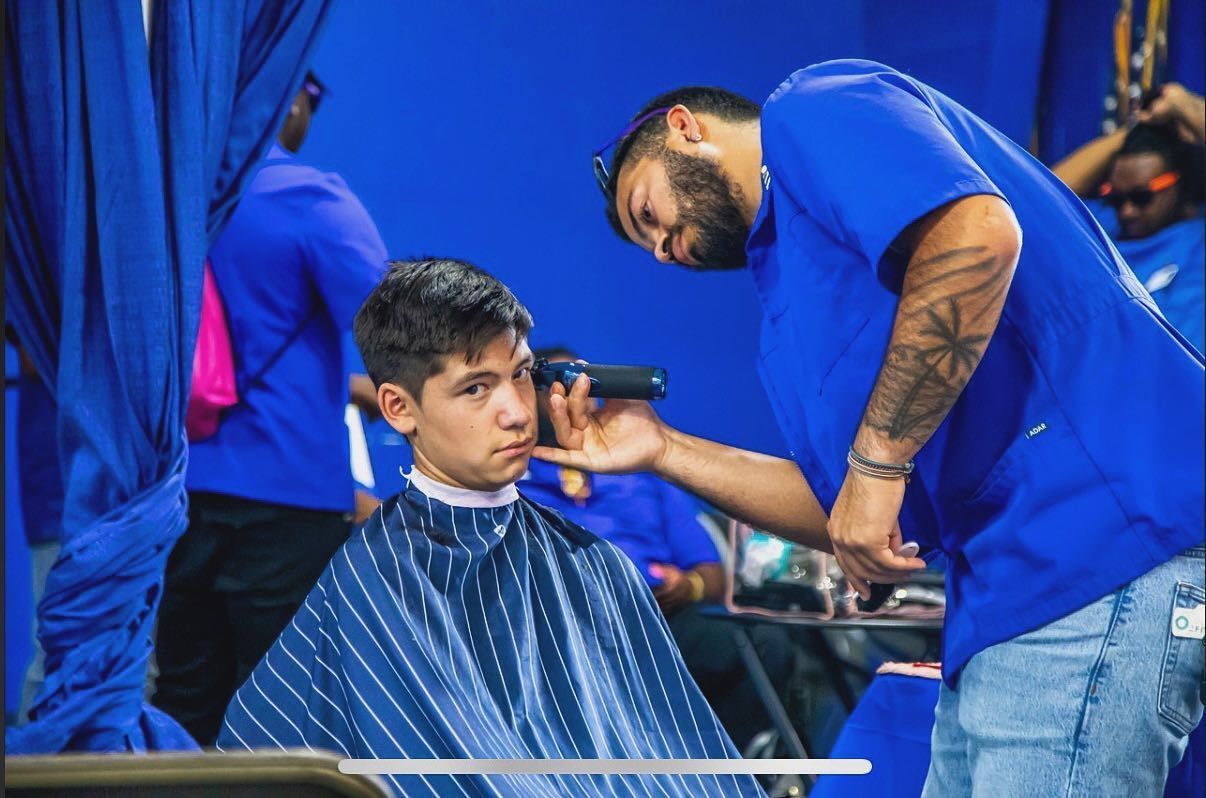 A man is getting his hair cut by a barber in a barber shop.