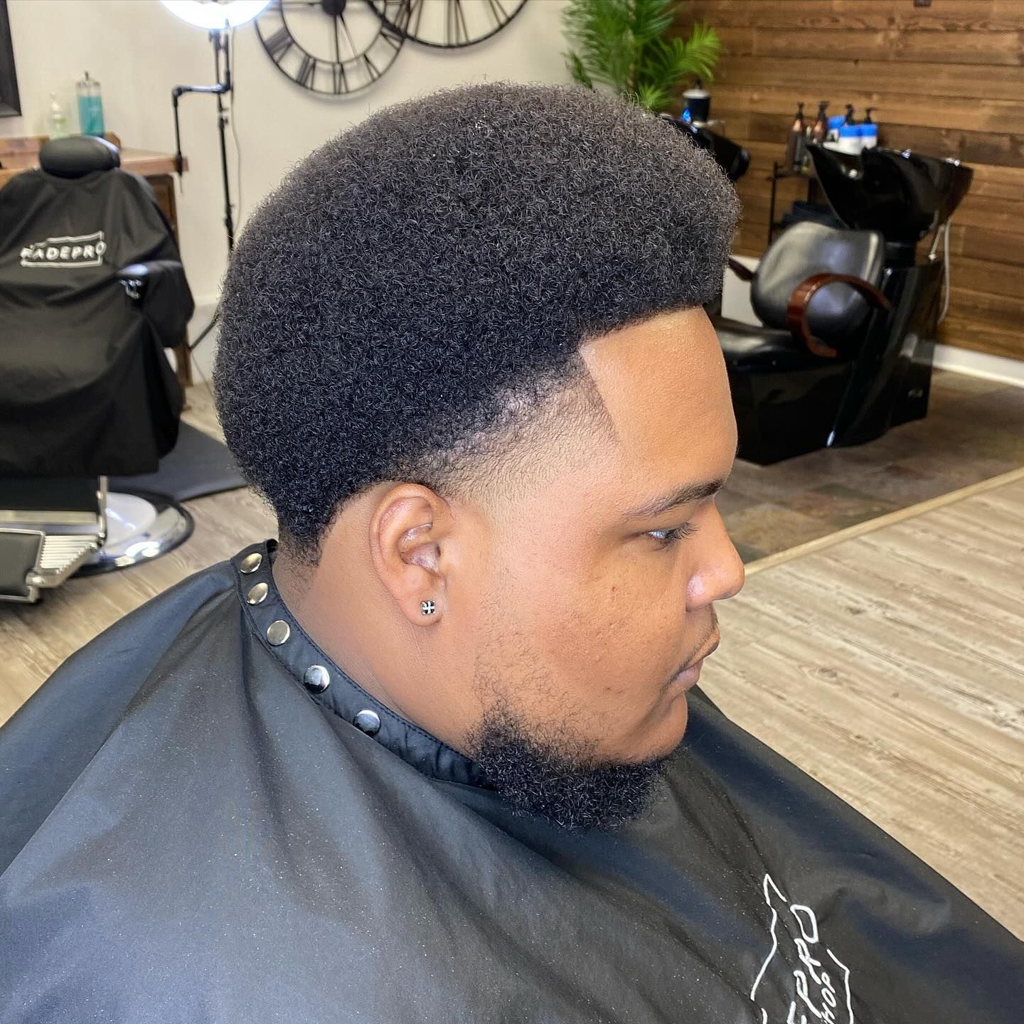 A man is getting his hair cut at a barber shop.