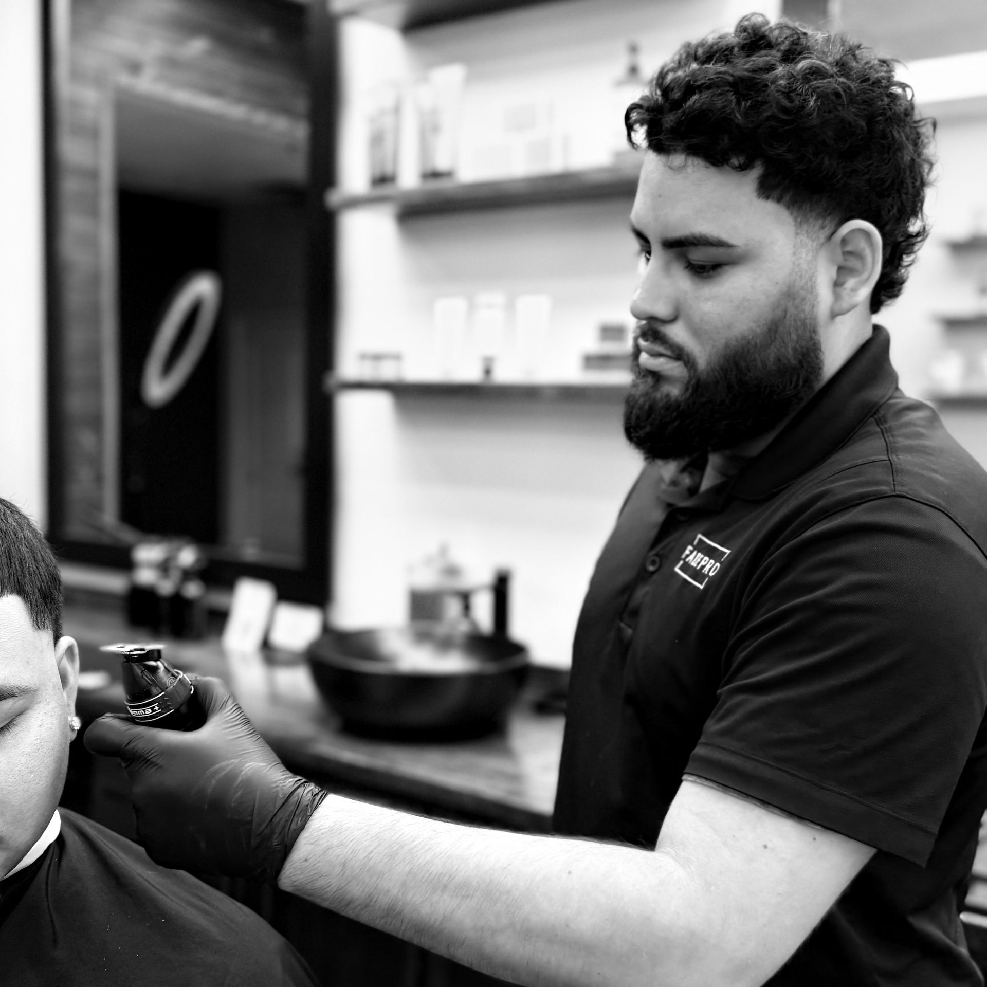A man is getting his hair cut by a barber in a barber shop.