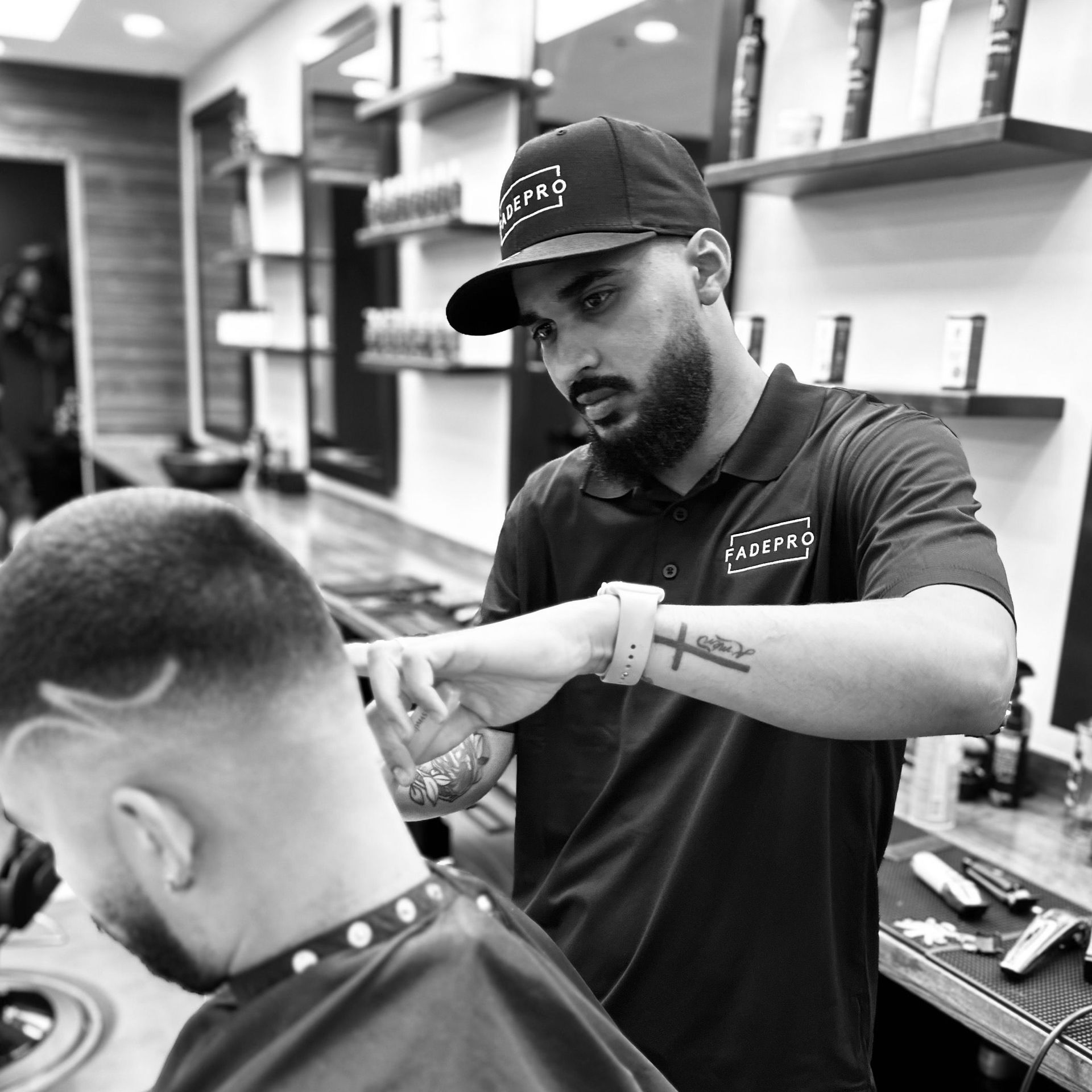 A man is getting his hair cut by a barber in a black and white photo.