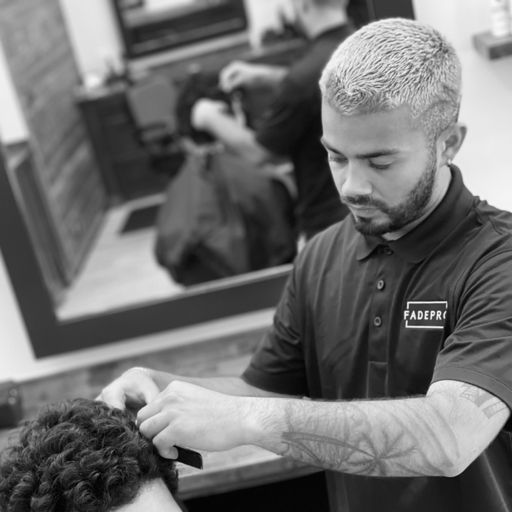 A man is cutting a man 's hair in a barber shop.