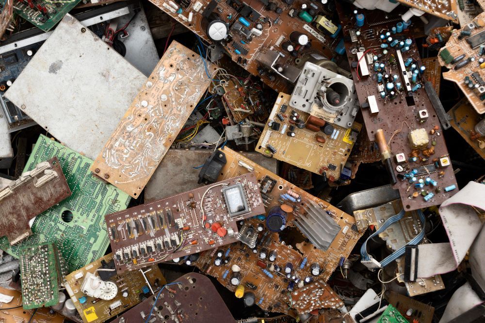 Pile of discarded electronic circuit boards with various components.