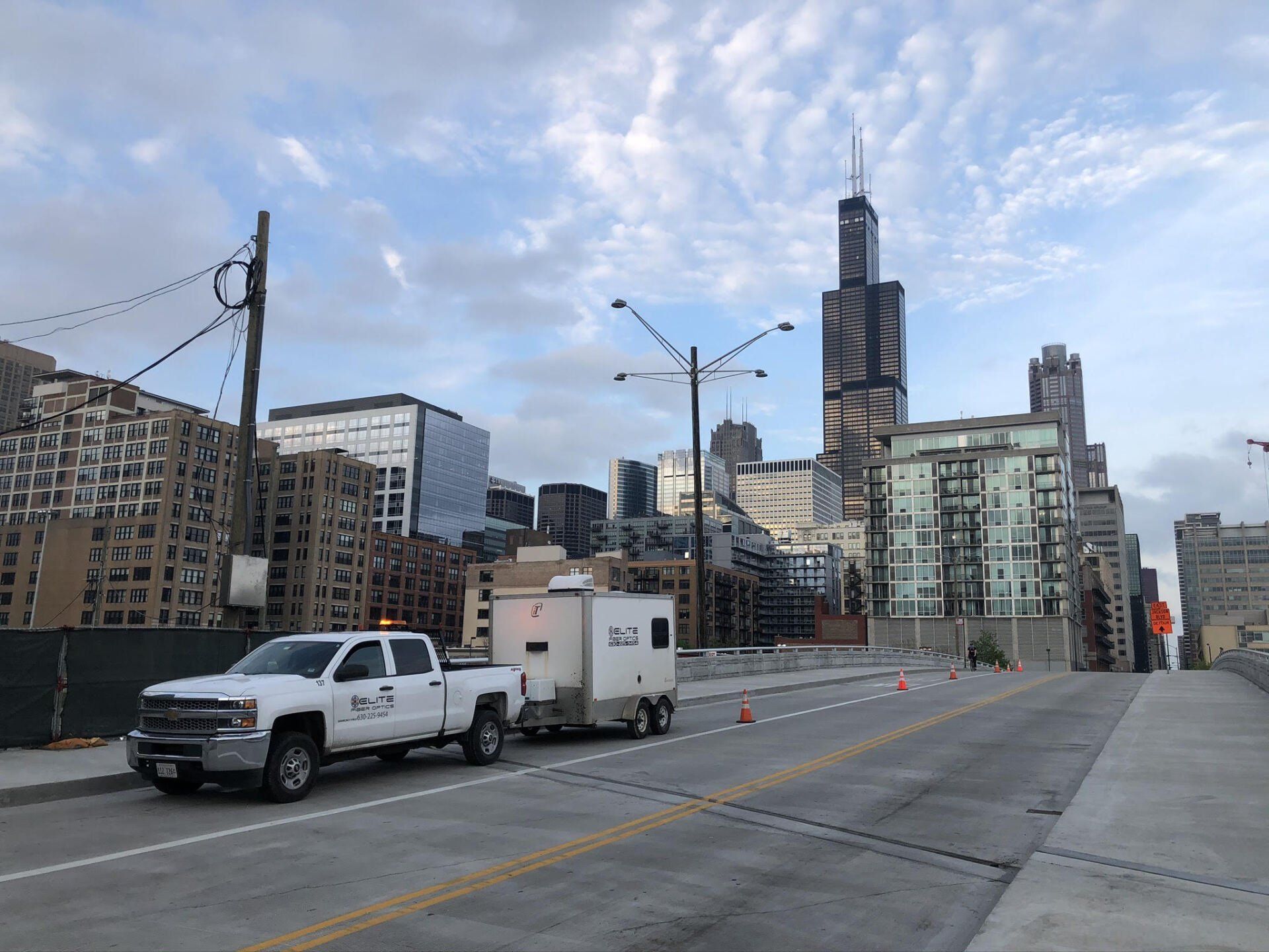 A truck is pulling a trailer down a city street.