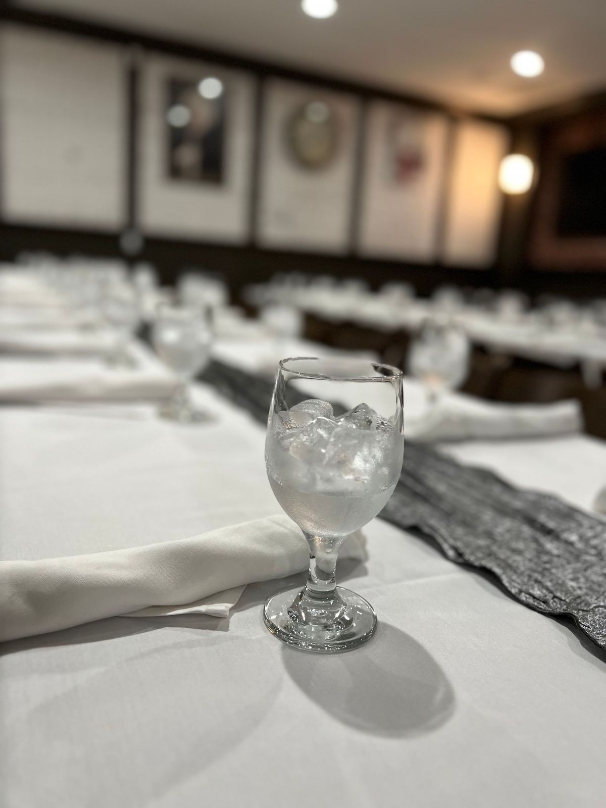 A wine glass filled with ice is sitting on a table.