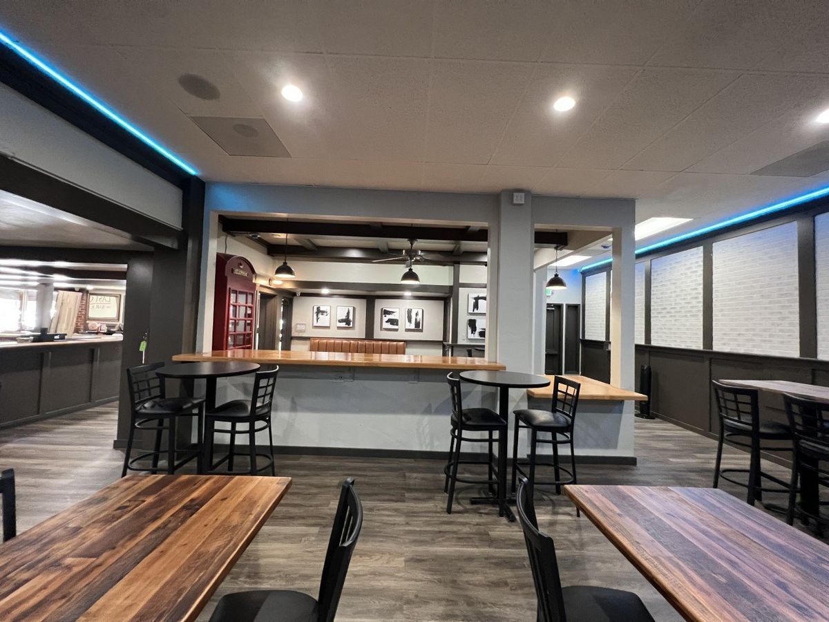 A restaurant with tables and chairs and a bar