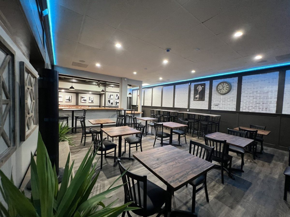 A restaurant with tables and chairs and a clock on the wall.