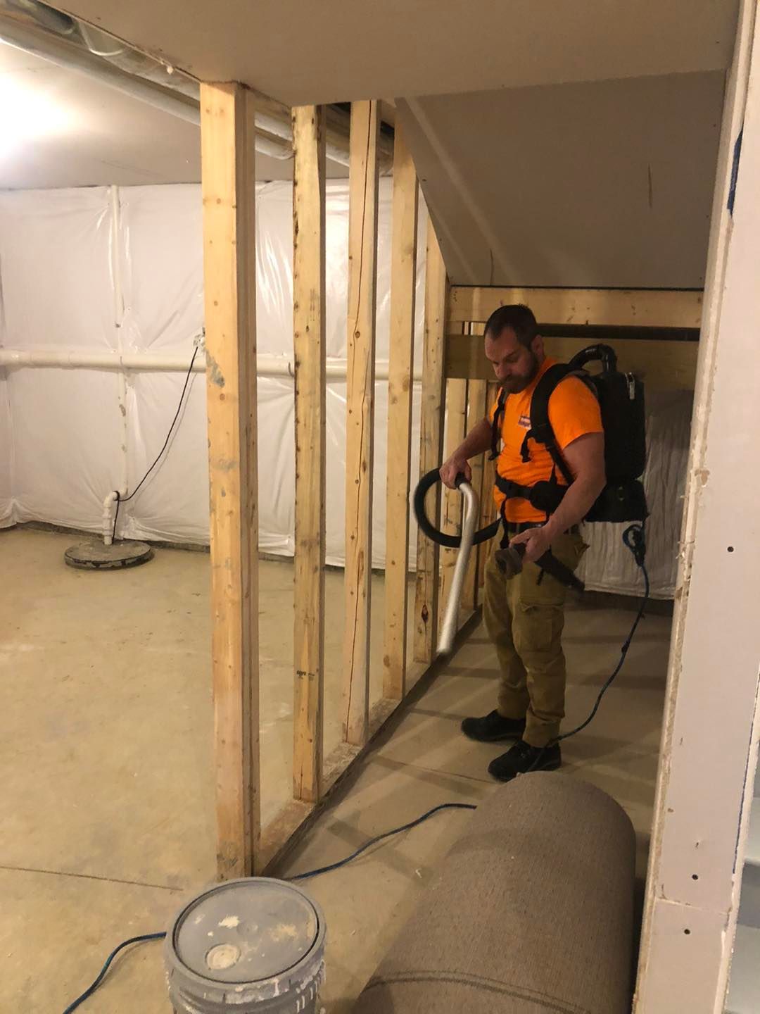 A man is standing in a basement holding a vacuum cleaner in Northeast, Ohio.