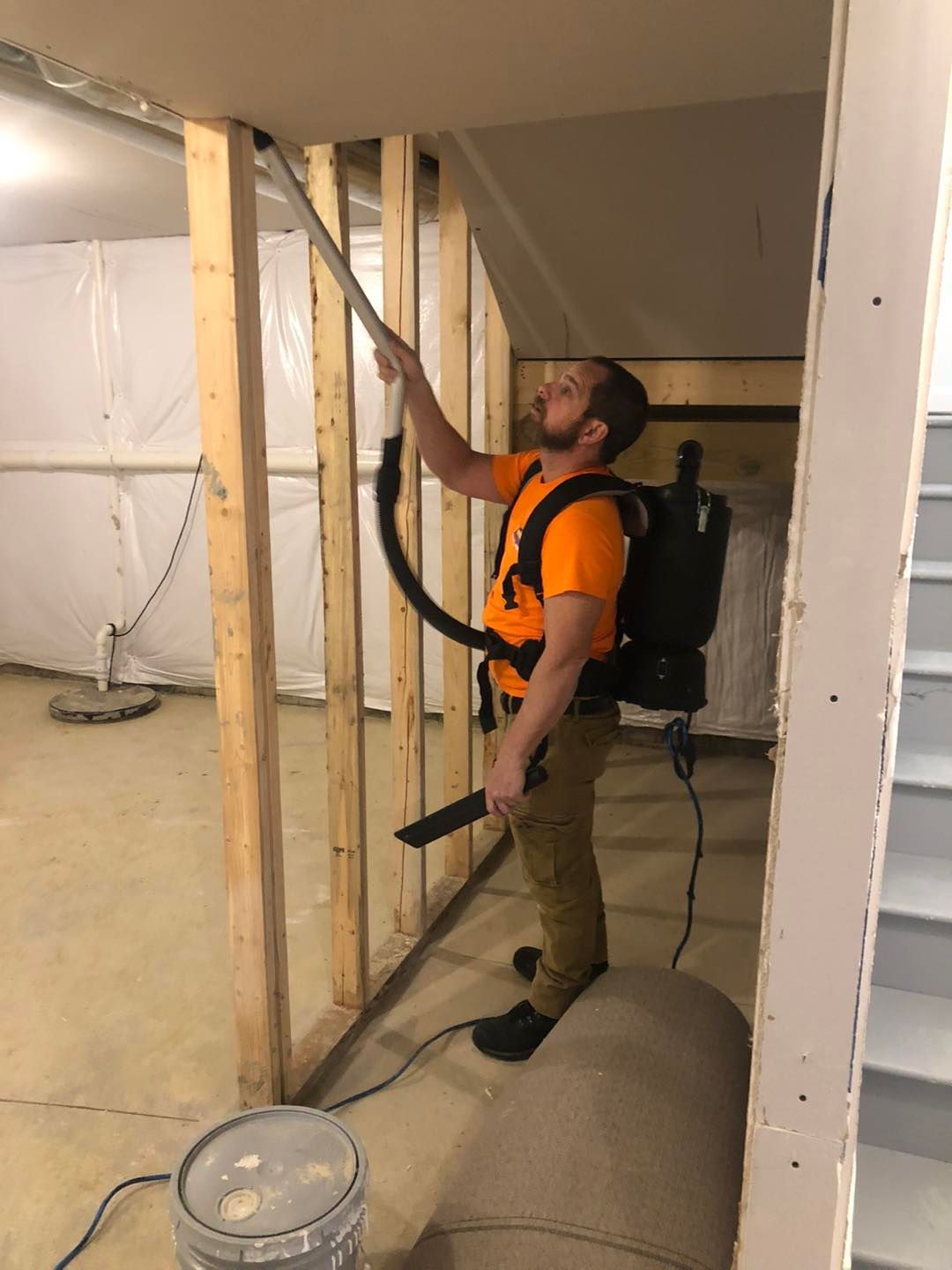 Man using a vacuum cleaner in a basement of a Cleveland home.