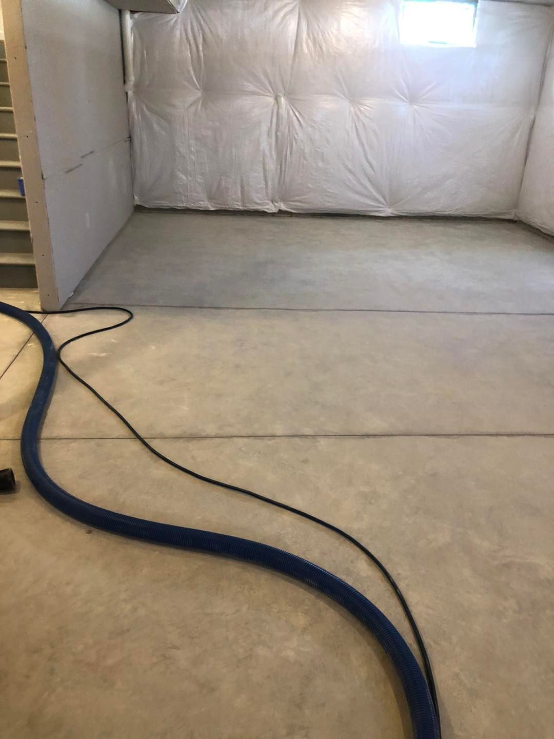 Basement scene with a vacuum cleaner sitting on the floor in a Cleveland home.