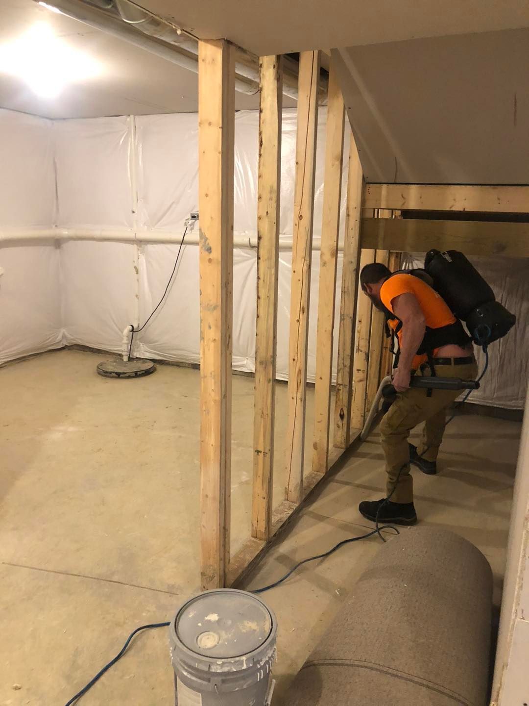 Man using a vacuum cleaner to clean a basement in a Cleveland home.