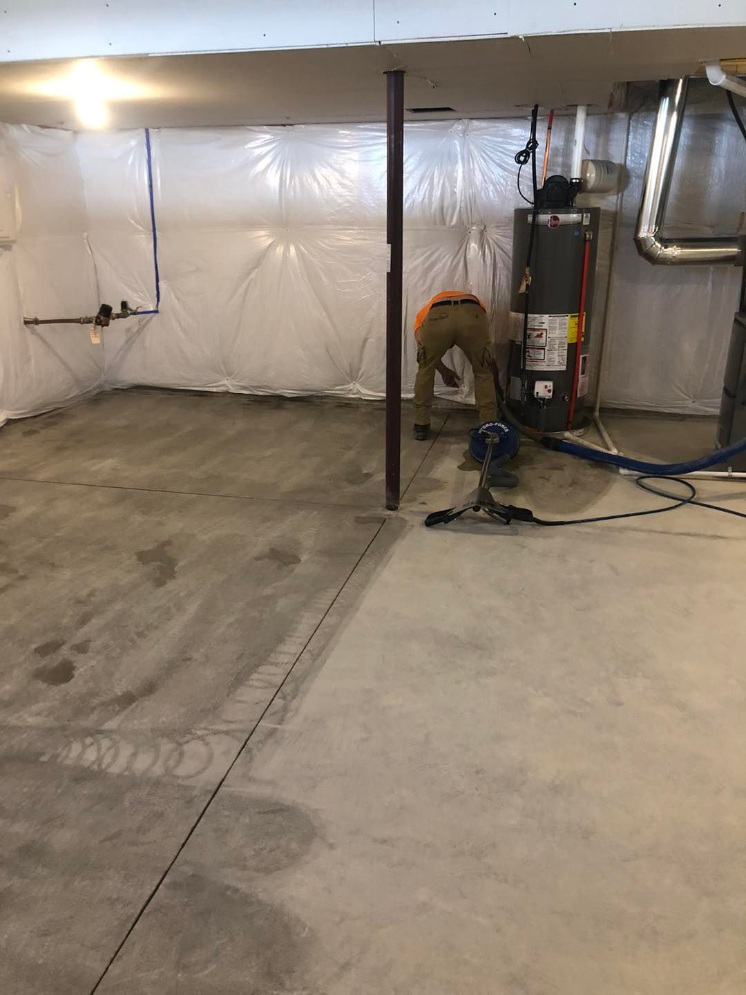 Basement being cleaned by a man using a vacuum cleaner in a Cleveland‑area property.